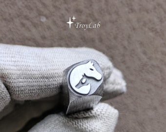May include: A silver-colored metal stamping tool featuring a raised design of a horse head silhouette. The tool has a square-shaped shaft and displays the text TroyLab with a small star icon above the brand name on the side of the metal body.