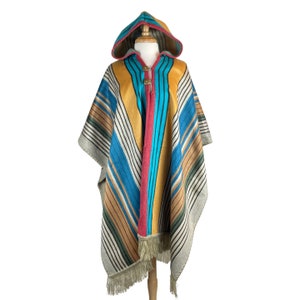 May include: A colorful striped poncho with a hood, featuring a yellow, blue, red, and brown color scheme. The poncho has a fringe trim and is displayed on a mannequin.