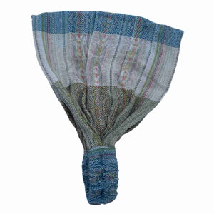 May include: A blue, green, and white patterned headband with a knotted design. The headband is made of woven fabric.