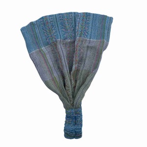 May include: A blue and green patterned headband with a woven design. The headband is tied at the back with a knot.