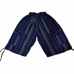 May include: Knee-length shorts in a dark blue, black, and white vertical striped pattern. These shorts feature an elastic waistband with a drawstring, two side cargo pockets with small orange buttons, and adjustable drawstrings at the leg hems.