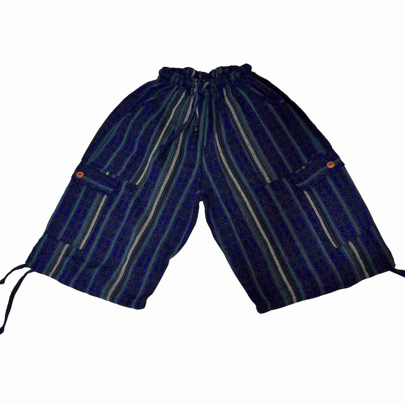 May include: Knee-length shorts in a dark blue, black, and white vertical striped pattern. These shorts feature an elastic waistband with a drawstring, two side cargo pockets with small orange buttons, and adjustable drawstrings at the leg hems.