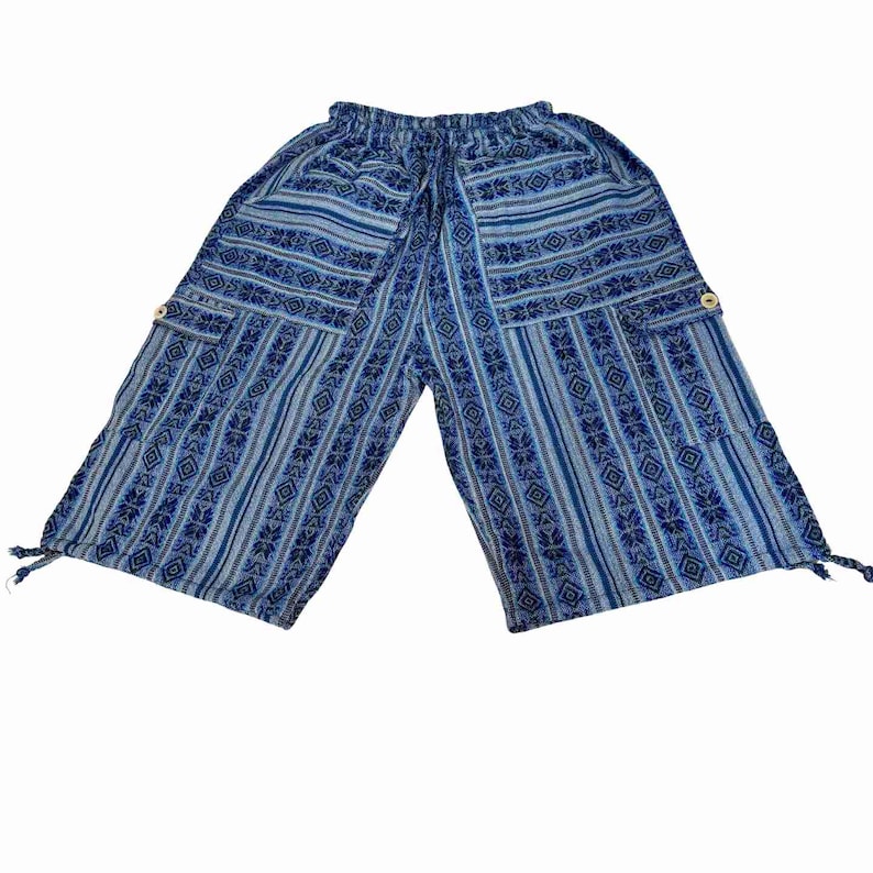 May include: Blue and light blue patterned cropped pants featuring an elastic waistband with a drawstring, two side cargo pockets with light-colored buttons, and adjustable tie-string closures at the bottom of each leg opening.