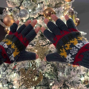 May include: A pair of fingerless gloves with a blue, red, white, and yellow geometric pattern. The gloves are made of a soft, knitted fabric.
