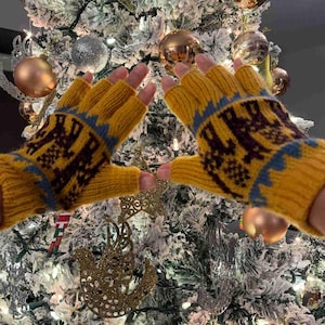 May include: A pair of yellow fingerless gloves with a blue and brown geometric pattern. The gloves are knitted and have a warm, cozy look.