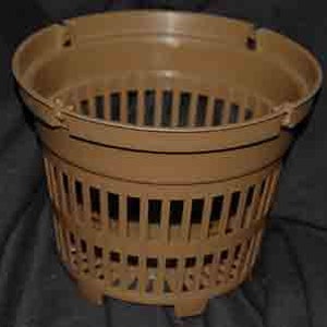 May include: A brown plastic plant pot with a slotted design. The pot has a round shape with a slightly flared rim and a built-in inner basket. The pot is designed for drainage and aeration, suitable for various plants.