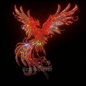 May include: A phoenix motif created with red, orange, and clear rhinestones against a black background. The bird is depicted with wings spread wide and a long, flowing tail. The text Next Clover is visible in small grey letters at the bottom.