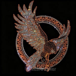 May include: A rhinestone transfer design featuring a soaring eagle with outstretched wings positioned in front of a circular frame. The eagle and the circular border are decorated with shimmering orange and silver crystals on a black background.
