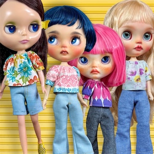 May include: Four fashion dolls with large eyes and colorful hair. Each doll is wearing a patterned top and denim pants. The dolls have different skin tones and hairstyles, and are posed against a yellow background.