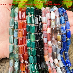 May include: Strands of gemstone beads in various colors, including green moss agate, red agate, green agate, black agate, pink agate, Botswana agate, and lapis lazuli. The beads are rectangular and strung together, showcasing a range of natural stone textures and hues.