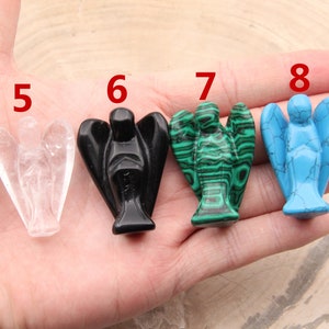 May include: Five carved angel figurines made of different stones. The angels are numbered 5 through 8. The angels are made of clear quartz, black obsidian, green malachite, and blue turquoise.