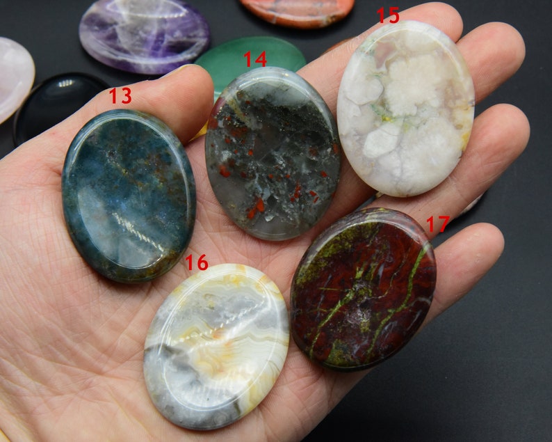 May include: Seven oval-shaped polished stones in various colors and patterns, including green, white, red, and black. The stones are arranged in a hand, with the numbers 13, 14, 15, 16, and 17 visible.