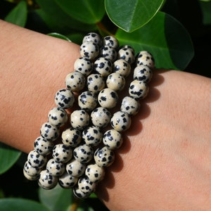 Puede incluir: Un brazalete hecho de múltiples hilos de cuentas de jaspe dalmata negro y blanco.