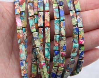 Può includere: Perle rettangolari multicolori in pietre preziose con un motivo maculato. Le perle sono infilate su un cordoncino e sono pronte per essere utilizzate per la creazione di gioielli.