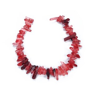 May include: A strand of red crystal points, arranged in a U-shape, on a white background.