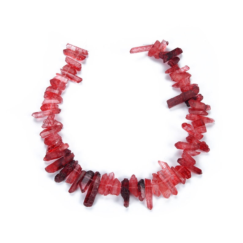 May include: A strand of red crystal points, arranged in a U-shape, on a white background.