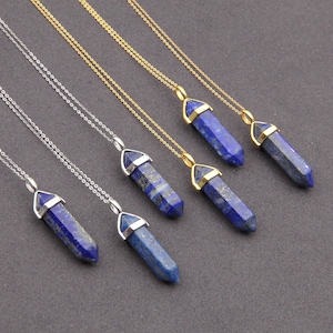 Puede incluir: Seis cadenas de plata y oro con colgantes de punta de cristal de lapislázuli azul. Los colgantes son de diferentes longitudes y tienen un engaste de oro o plata.