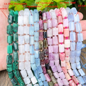May include: A hand holds strands of gemstone beads in various colors. The beads are rectangular and strung together. Colors include green malachite, white, light blue aquamarine, pink, and lavender tourmaline, and pink opal. The beads are for jewelry making.