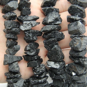 Peut inclure: Un brin de perles de pierres précieuses naturelles noires, rugueuses. Les perles sont de forme et de taille irrégulières et ont une finition mate.