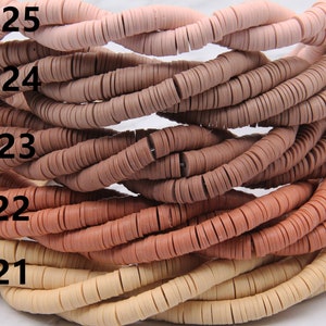 May include: A close-up of five strands of round, flat, clay beads in shades of beige, light brown, brown, and pink. The beads are stacked on top of each other, with the lightest color at the bottom and the darkest color at the top. The beads are labeled with numbers 21 through 25.