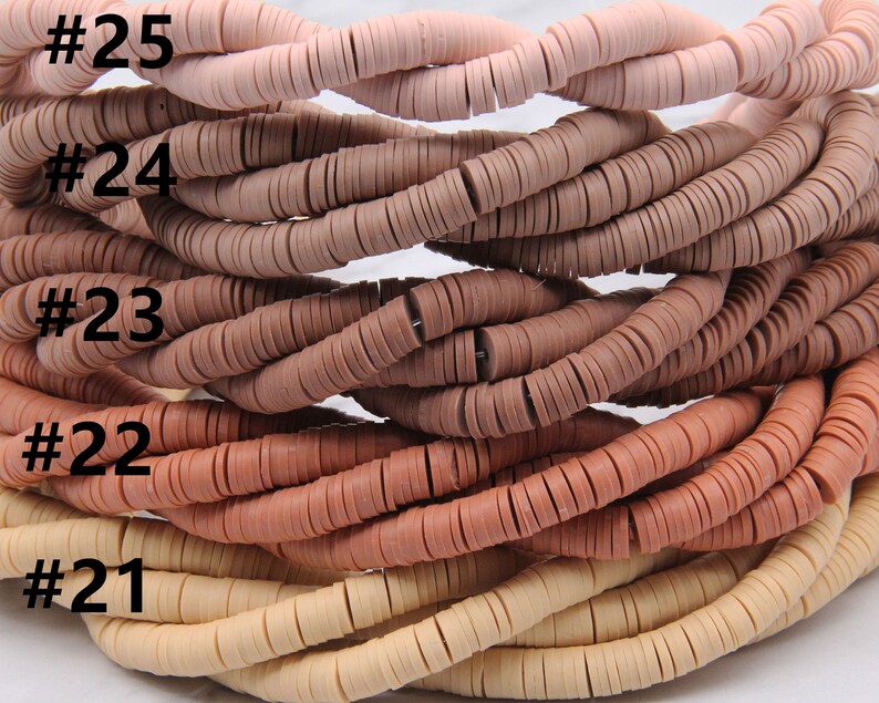 May include: A close-up of five strands of round, flat, clay beads in shades of beige, light brown, brown, and pink. The beads are stacked on top of each other, with the lightest color at the bottom and the darkest color at the top. The beads are labeled with numbers 21 through 25.