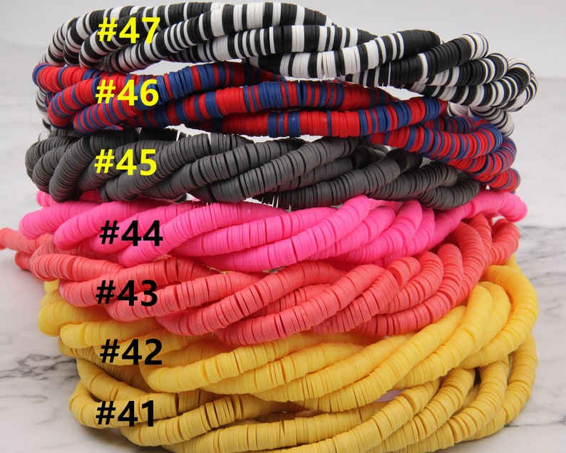 May include: A stack of colorful round polymer clay beads in various colors, including black and white, red, blue, gray, pink, orange, and yellow. The beads are numbered #41 through #47.