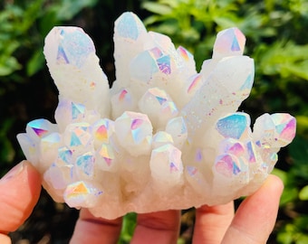 May include: A cluster of white iridescent quartz crystals with a rainbow sheen. The crystals are arranged in a cluster and have a variety of shapes and sizes.