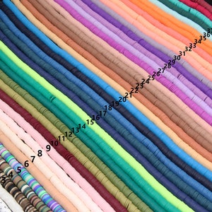 May include: A collection of 40 strands of colorful polymer clay beads. Each strand is made up of small, flat, round beads. The beads are arranged in a rainbow pattern, with each strand a different color. The strands are numbered from 1 to 40.