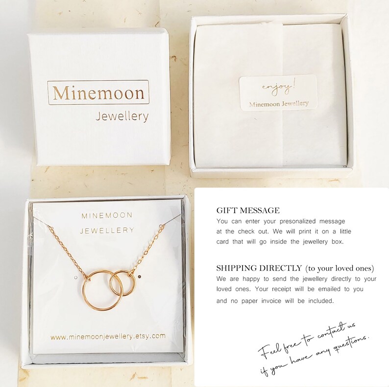 May include: A gold necklace with two interlocking circles, presented in a white box with the text "Minemoon Jewellery". The box is on a beige surface. The text "Feel free to contact us if you have any questions." is written in black ink on a white background.