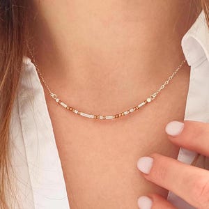 May include: A delicate silver chain necklace with a row of alternating silver and copper beads.