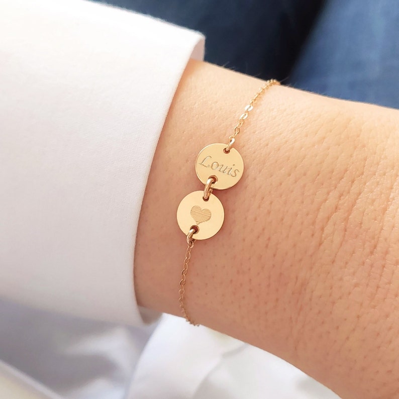 K&ouml;nnte beinhalten: Goldkette Armband mit zwei runden Anh&auml;ngern. Ein Anh&auml;nger hat den Namen "Louis" eingraviert, der andere Anh&auml;nger hat ein Herz eingraviert.