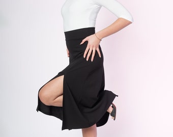 May include: A white three-quarter sleeve top with a scoop neckline paired with a high-waisted black midi skirt featuring a prominent side slit. The skirt has a fitted waistband and a flared hemline, complemented by black strappy high-heeled sandals.
