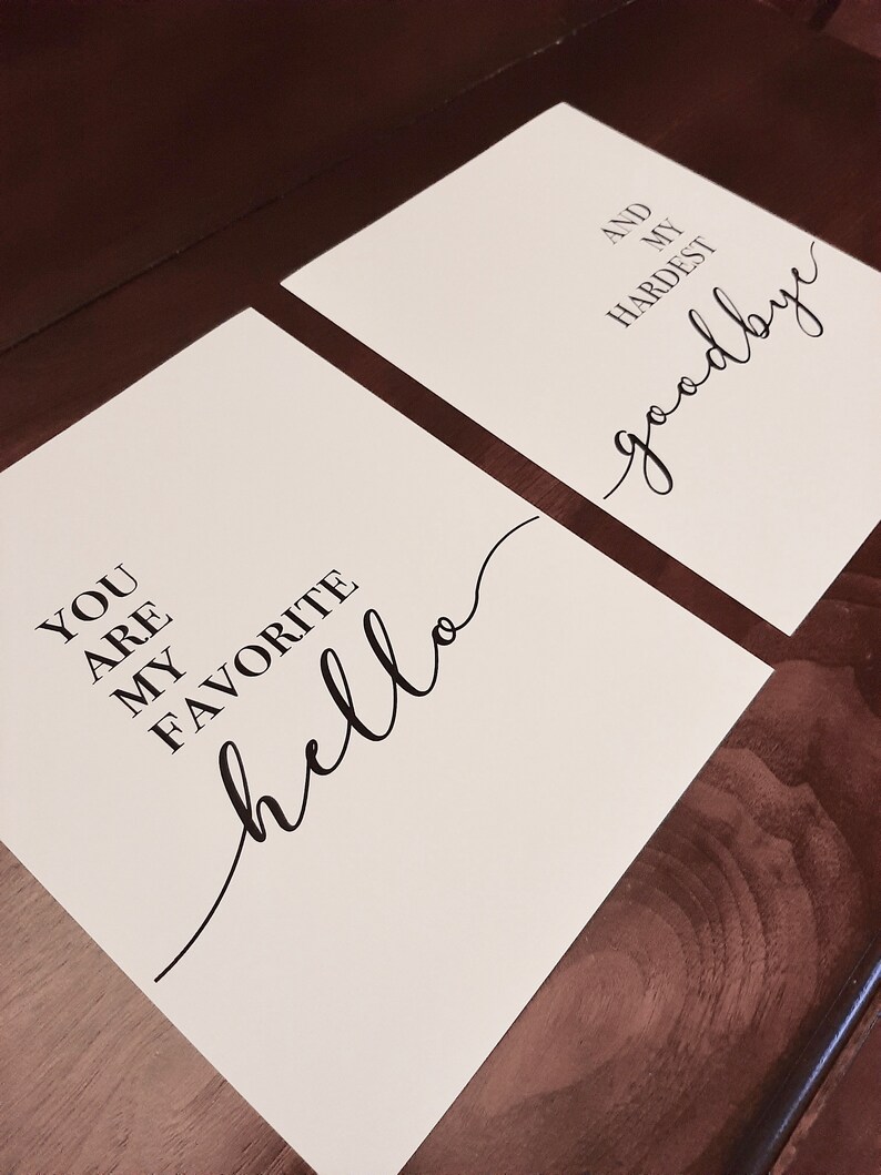 Puede incluir: Dos impresiones blancas con texto negro. La primera impresi&oacute;n dice "You are my favorite hello". La segunda impresi&oacute;n dice "And my hardest goodbye".