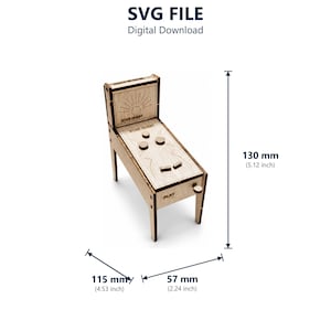 May include: A laser-cut wooden pinball machine model labelled Star Quest with a vertical backboard, a playfield with circular bumpers, and a side plunger. The dimensions are 130 mm (5.12 inch) high, 115 mm (4.53 inch) deep, and 57 mm (2.24 inch) wide.