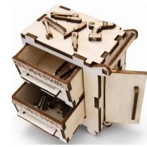 Puede incluir: Una caja de herramientas de juguete de madera con dos cajones y una puerta lateral. La parte superior de la caja de herramientas tiene varias herramientas de juguete de madera, incluyendo llaves y un taladro. Los cajones están abiertos, revelando más herramientas de juguete.