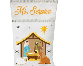 Puede incluir: Calcetín de Navidad blanco con una escena de la natividad y tres reyes magos. El calcetín está decorado con pedrería y copos de nieve. El calcetín está personalizado con el nombre "Sra. Serpico".