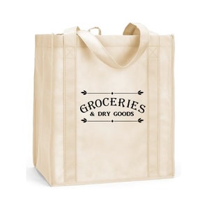 May include: A beige reusable tote bag with black handles and the text "GROCERIES & DRY GOODS" printed on the front.