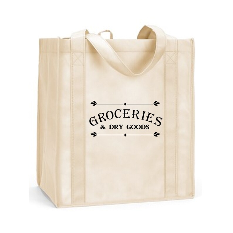 May include: A beige reusable tote bag with black handles and the text "GROCERIES & DRY GOODS" printed on the front.