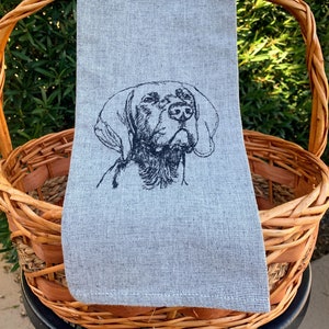 May include: A gray kitchen towel with a black embroidered image of a dog's head.