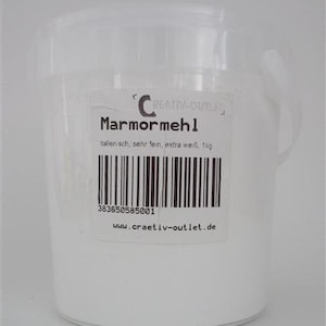 Könnte beinhalten: Ein weißer Plastik-Eimer gefüllt mit weißem Marmorpulver. Das Etikett lautet "Marmormehl" mit dem Text "italien sch, sehr fein, extra weiß, 1kg" und einem Barcode. Die Website-Adresse "www.craetiv-outlet.de" ist unter dem Barcode aufgedruckt.
