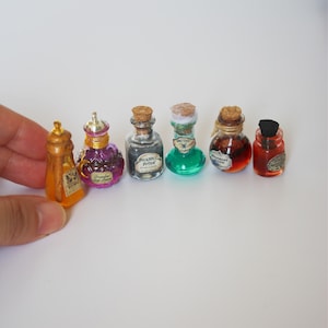 Puede incluir: Una colección de botellas de pociones en miniatura de varias formas y colores. Las botellas están llenas de líquidos en tonos naranja, morado, gris, verde y rojo. Algunas botellas tienen tapones de corcho, otras tapas decorativas. Se ven etiquetas en algunas botellas.