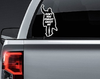May include: A white vinyl decal of a person with their arm raised in the air, with the text "Don't you forget about me" underneath. The decal is on a black background.