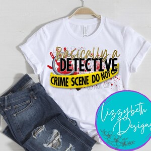 May include: White t-shirt with a gold glitter graphic that says "Basically a Detective Crime Scene Do Not Cross" with a red magnifying glass and blood splatter. The graphic is on a yellow caution tape background.