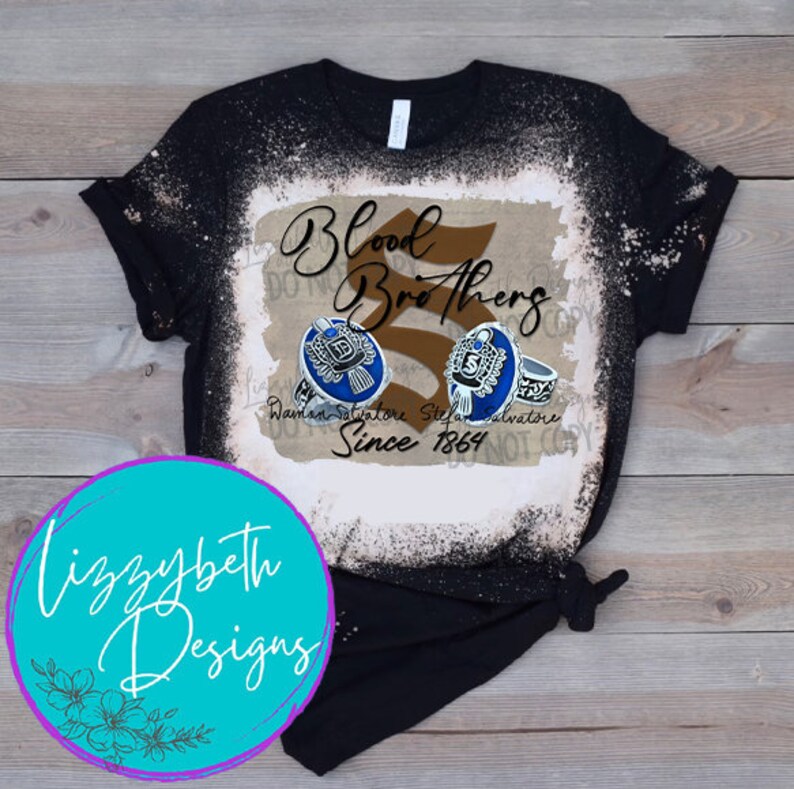 May include: A black t-shirt with a bleach-splattered design featuring the text "Blood Brothers" and two rings with the text "Damon Salvatore" and "Stefan Salvatore" and the date "Since 1864".