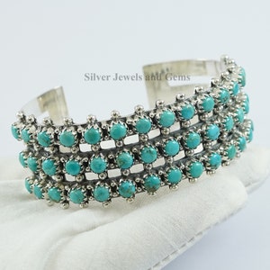 Könnte beinhalten: Ein silbernes Armreif mit Türkis-Steinen, die in einem Gittermuster gesetzt sind. Das Armband hat vier Reihen von Steinen und wurde von Silver Jewels and Gems hergestellt.