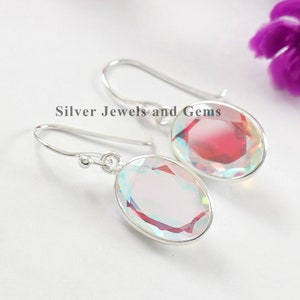 Puede incluir: Un par de pendientes de plata con piedras preciosas iridiscentes de forma ovalada. Los pendientes tienen un dise&ntilde;o sencillo y son perfectos para el uso diario.