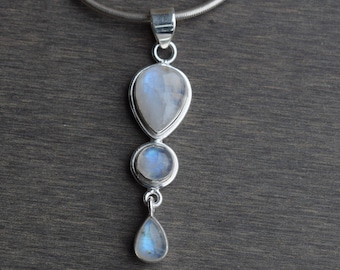 May include: A silver pendant necklace with three teardrop-shaped moonstone stones. The stones are iridescent and have a blue sheen.