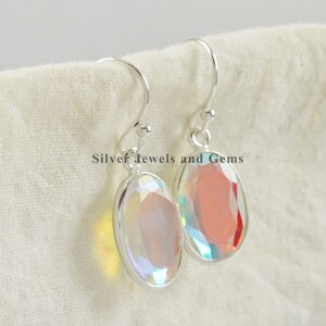 Puede incluir: Un par de pendientes de plata con piedras ovaladas iridiscentes. Los pendientes tienen un dise&ntilde;o sencillo y son perfectos para el uso diario.