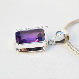 May include: A silver pendant featuring a large, rectangular, purple amethyst gemstone. The pendant is on a silver chain.