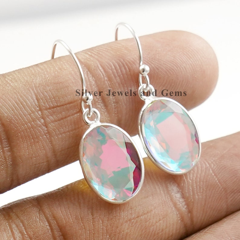 Puede incluir: Pendientes de plata con piedras preciosas iridiscentes de forma ovalada. Las piedras preciosas presentan un efecto arco&iacute;ris con tonos de rosa, azul y verde.